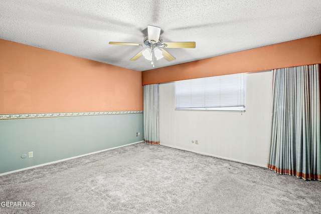 carpeted spare room featuring a textured ceiling and ceiling fan