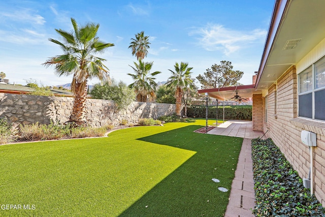 view of yard featuring ceiling fan and a patio