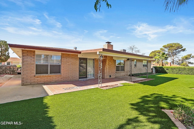 back of house with a lawn and a patio