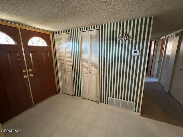 entrance foyer with a textured ceiling and a chandelier