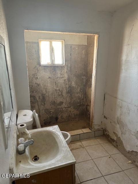 bathroom featuring toilet, walk in shower, vanity, and tile patterned flooring