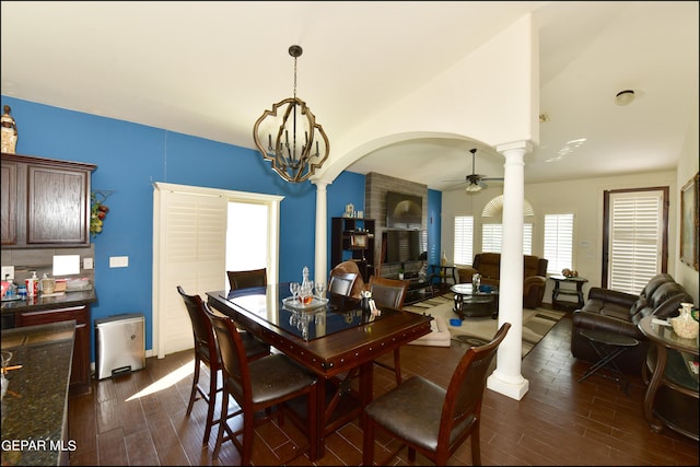 dining space featuring ceiling fan with notable chandelier, dark hardwood / wood-style floors, and ornate columns