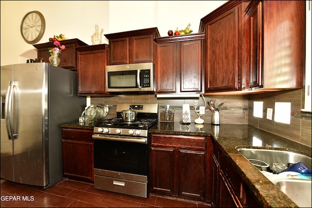 kitchen with dark stone counters, appliances with stainless steel finishes, sink, and tasteful backsplash