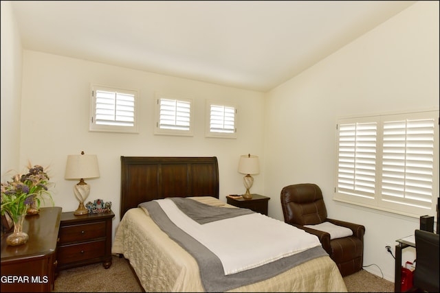 carpeted bedroom featuring vaulted ceiling and multiple windows