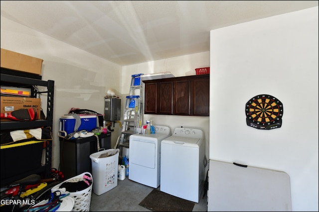 clothes washing area with separate washer and dryer and cabinets