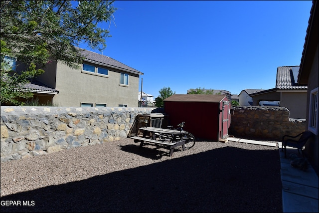 view of yard with a storage unit and a patio area