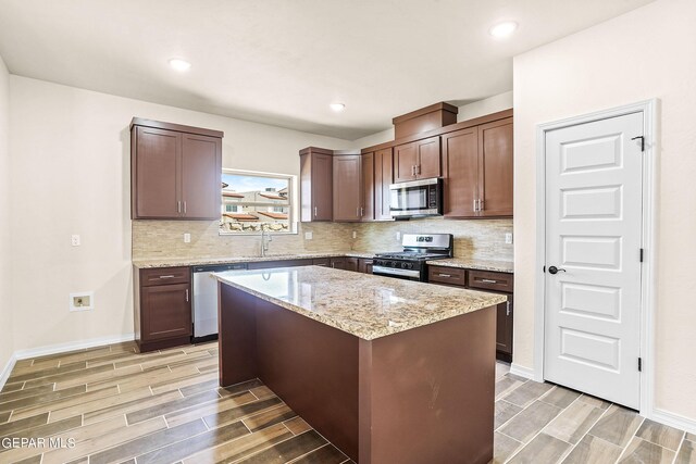 kitchen featuring dark brown cabinets, stainless steel appliances, light hardwood / wood-style floors, and a kitchen island