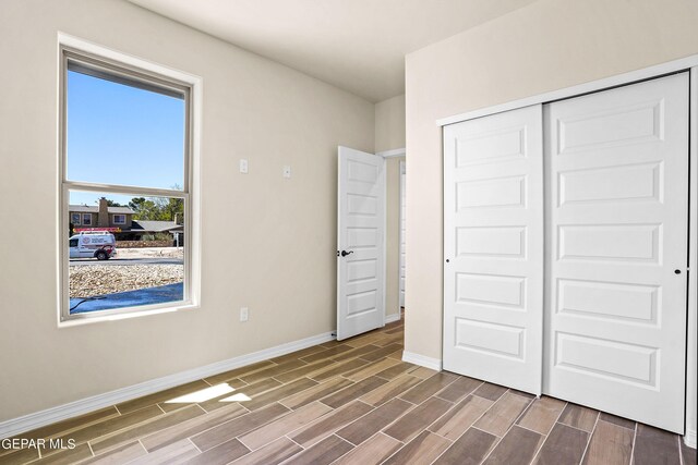 unfurnished bedroom with hardwood / wood-style flooring and a closet