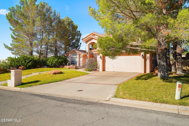 851 Via Alegre Ln, El Paso, TX 79912 - view of property hidden behind natural elements featuring concrete driveway, a front lawn, an attached garage, and stucco siding