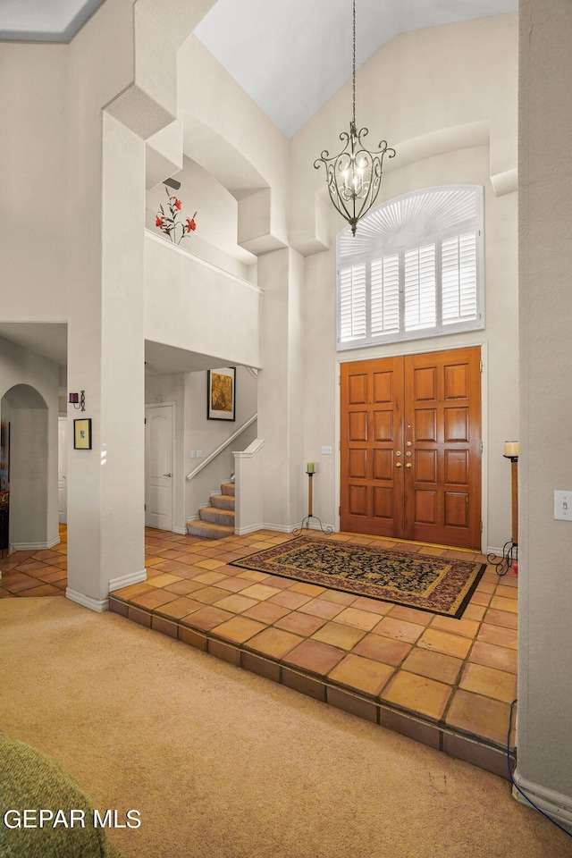 851 Via Alegre Ln, El Paso, TX 79912 - entrance foyer featuring high vaulted ceiling, stairs, a chandelier, carpet, and arched walkways