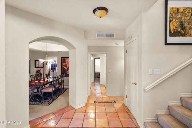 851 Via Alegre Ln, El Paso, TX 79912 - foyer with a chandelier, arched walkways, stairway, light tile patterned floors, and light colored carpet