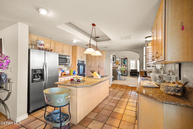 kitchen with dark stone countertops, a breakfast bar, a kitchen island, stainless steel appliances, and decorative light fixtures