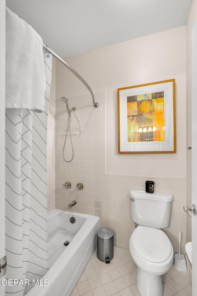 bathroom featuring tile walls, shower / bath combo, toilet, and tile patterned floors