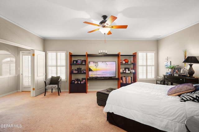 bedroom featuring ceiling fan, crown molding, light carpet, and multiple windows