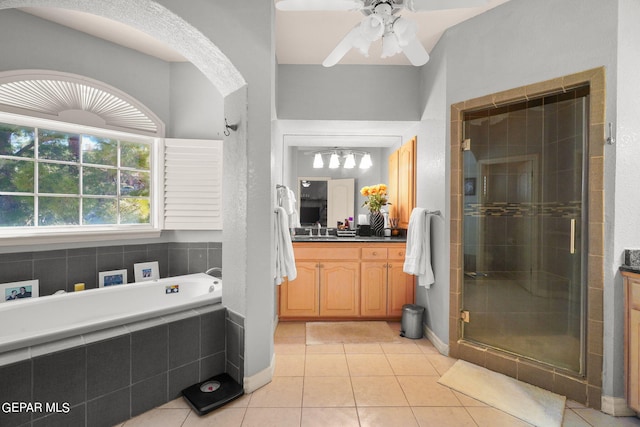 bathroom with tile patterned floors, ceiling fan, vanity, and separate shower and tub