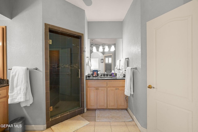 bathroom with tile patterned floors, walk in shower, and vanity