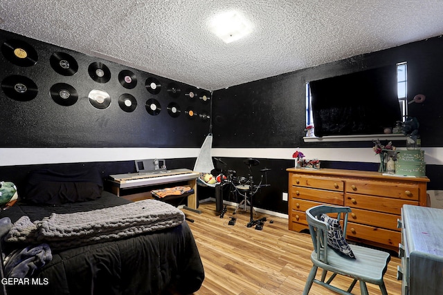 bedroom featuring light hardwood / wood-style floors and a textured ceiling