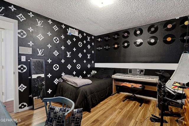 bedroom featuring wood-type flooring and a textured ceiling