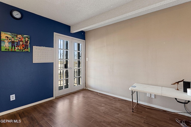 interior space featuring dark wood-type flooring, french doors, and a textured ceiling