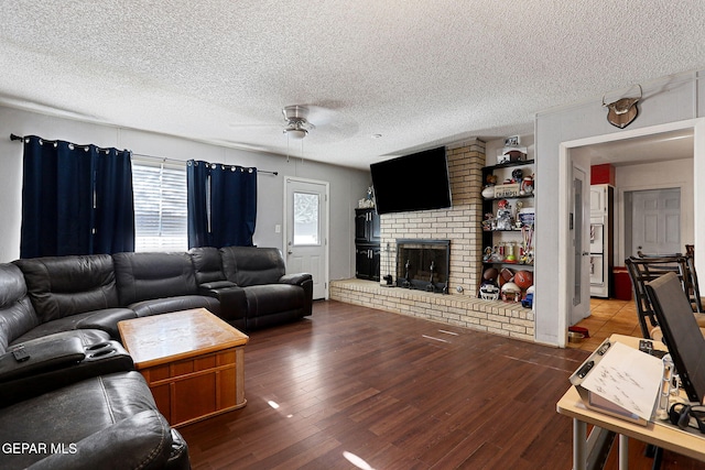 living room featuring a fireplace, hardwood / wood-style floors, ceiling fan, and a textured ceiling