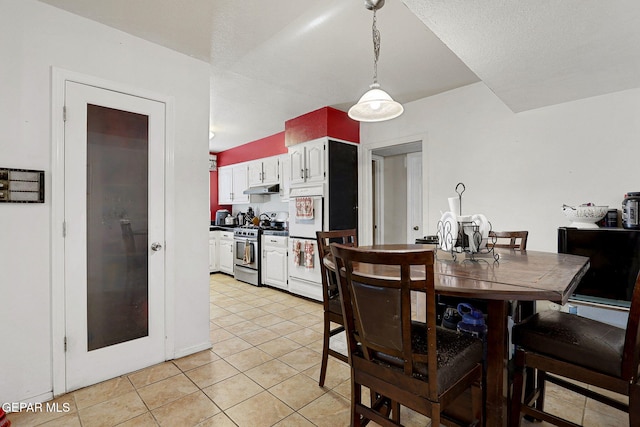 dining room featuring a textured ceiling and light tile patterned flooring