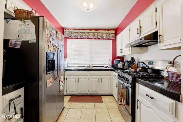 kitchen featuring light tile patterned flooring, sink, appliances with stainless steel finishes, a textured ceiling, and white cabinets