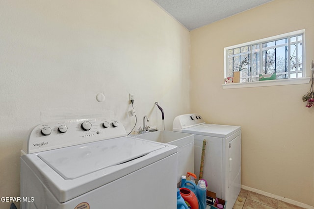 washroom featuring a textured ceiling, light tile patterned floors, and separate washer and dryer