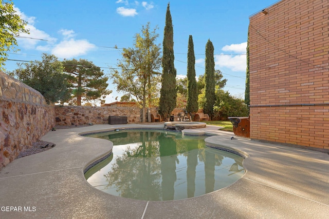 view of pool featuring a patio and an in ground hot tub