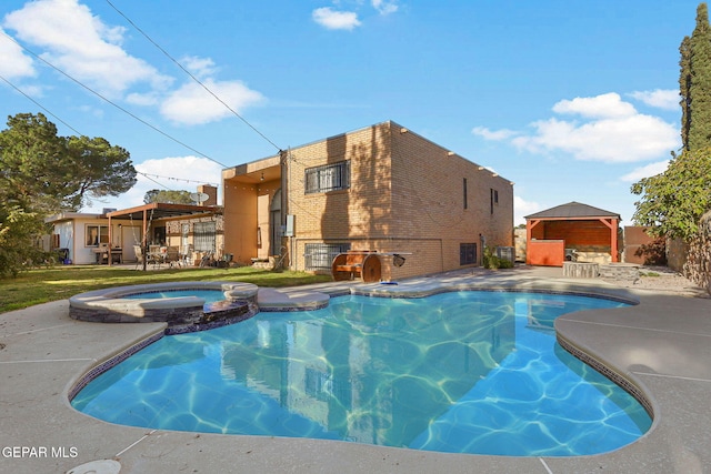 view of pool featuring a patio and an in ground hot tub