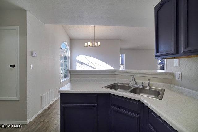 kitchen featuring dark hardwood / wood-style floors, sink, pendant lighting, and a chandelier