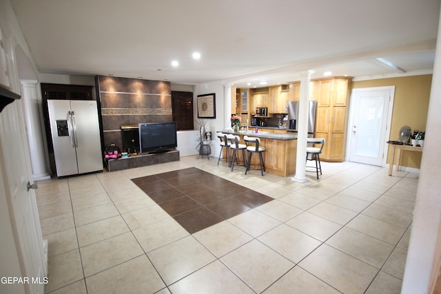 kitchen with appliances with stainless steel finishes, a kitchen breakfast bar, and light tile patterned floors