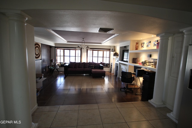 living room featuring dark tile patterned flooring, a tray ceiling, and a textured ceiling