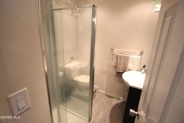 bathroom with walk in shower, vanity, and toilet