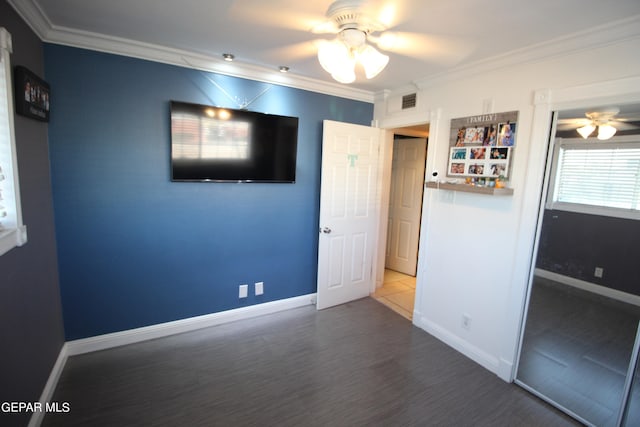 unfurnished bedroom with ceiling fan, crown molding, and wood-type flooring