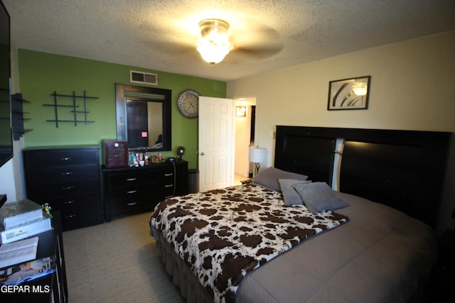 bedroom with ceiling fan and a textured ceiling