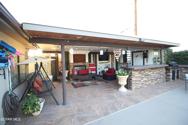 view of patio with exterior kitchen and a grill