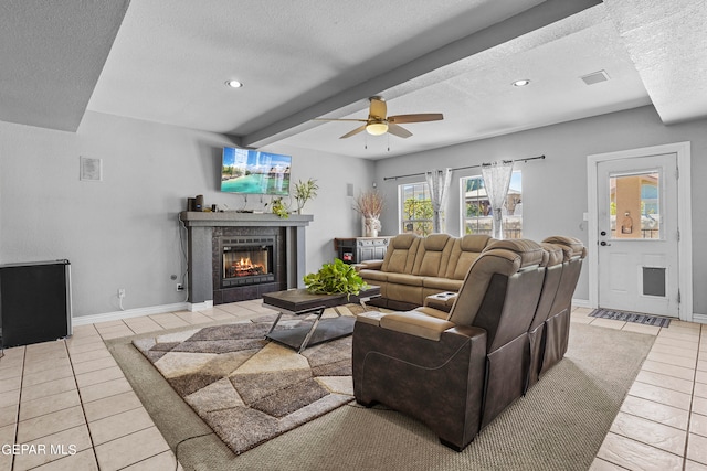 living room with a textured ceiling, beam ceiling, and light tile patterned floors