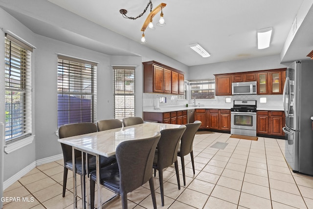 kitchen featuring stainless steel appliances, light tile patterned floors, and a healthy amount of sunlight