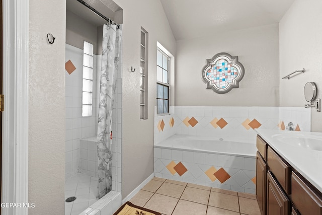 bathroom featuring tile patterned floors, vaulted ceiling, vanity, and shower with separate bathtub