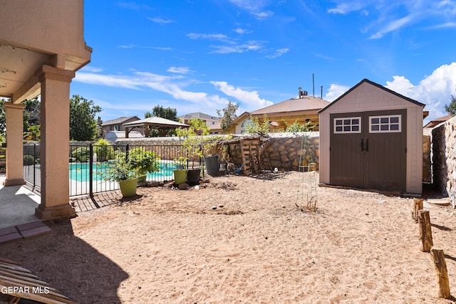 view of yard with a fenced in pool and a shed