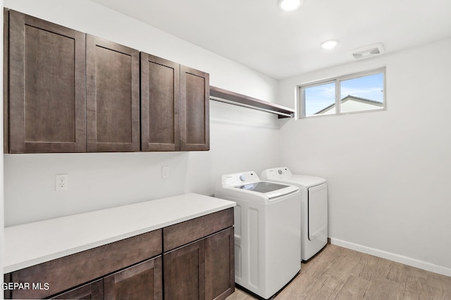 washroom with cabinets, light hardwood / wood-style floors, and separate washer and dryer