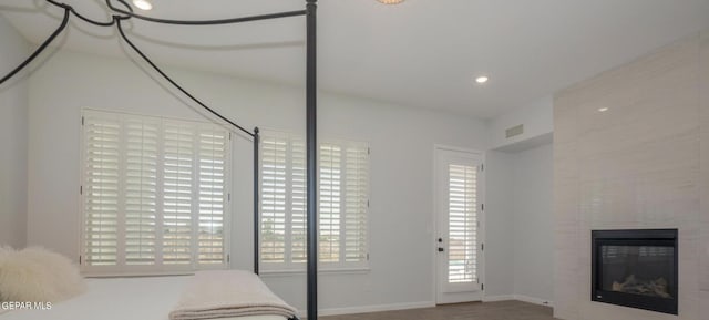 unfurnished bedroom with a tiled fireplace and hardwood / wood-style flooring