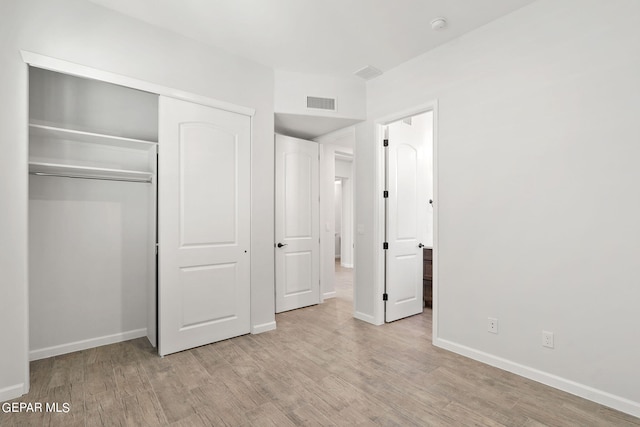 unfurnished bedroom featuring light hardwood / wood-style flooring and a closet