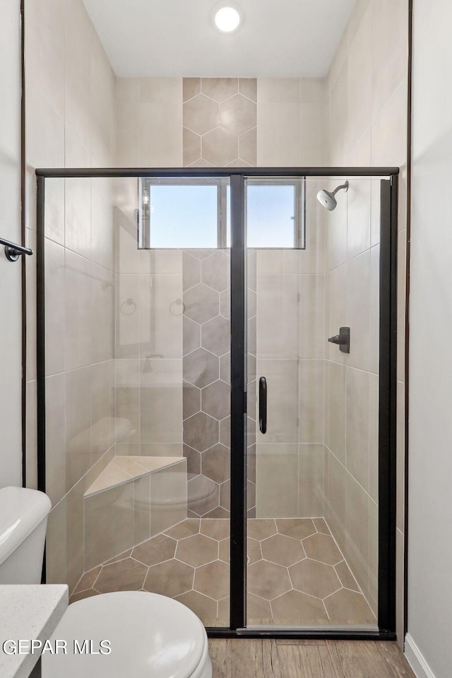 bathroom with an enclosed shower, hardwood / wood-style flooring, vanity, and toilet