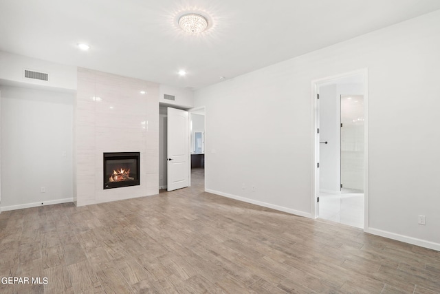 unfurnished living room featuring wood-type flooring and a fireplace