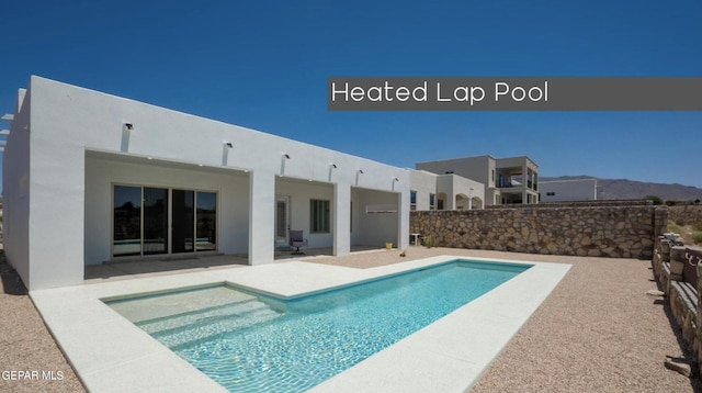 view of swimming pool with a mountain view and a patio area