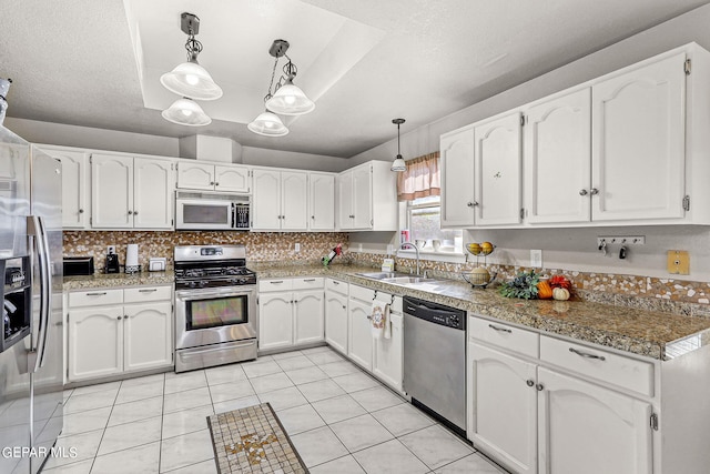 kitchen with pendant lighting, white cabinetry, sink, and stainless steel appliances