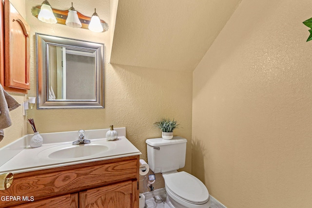 bathroom with vanity, lofted ceiling, and toilet