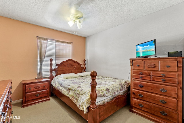 bedroom featuring light carpet, a textured ceiling, and ceiling fan