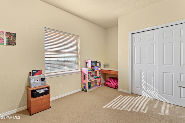 recreation room with carpet floors and a textured ceiling